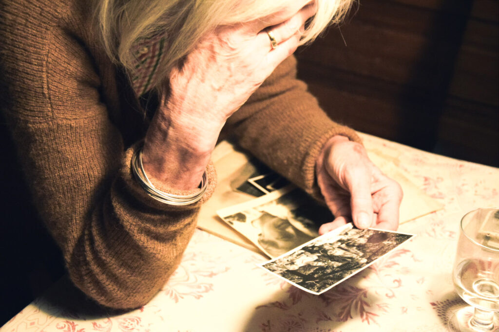 old woman reminiscing while looking at an old picture
